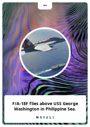 F/A-18F flies above USS George Washington in Philippine Sea.