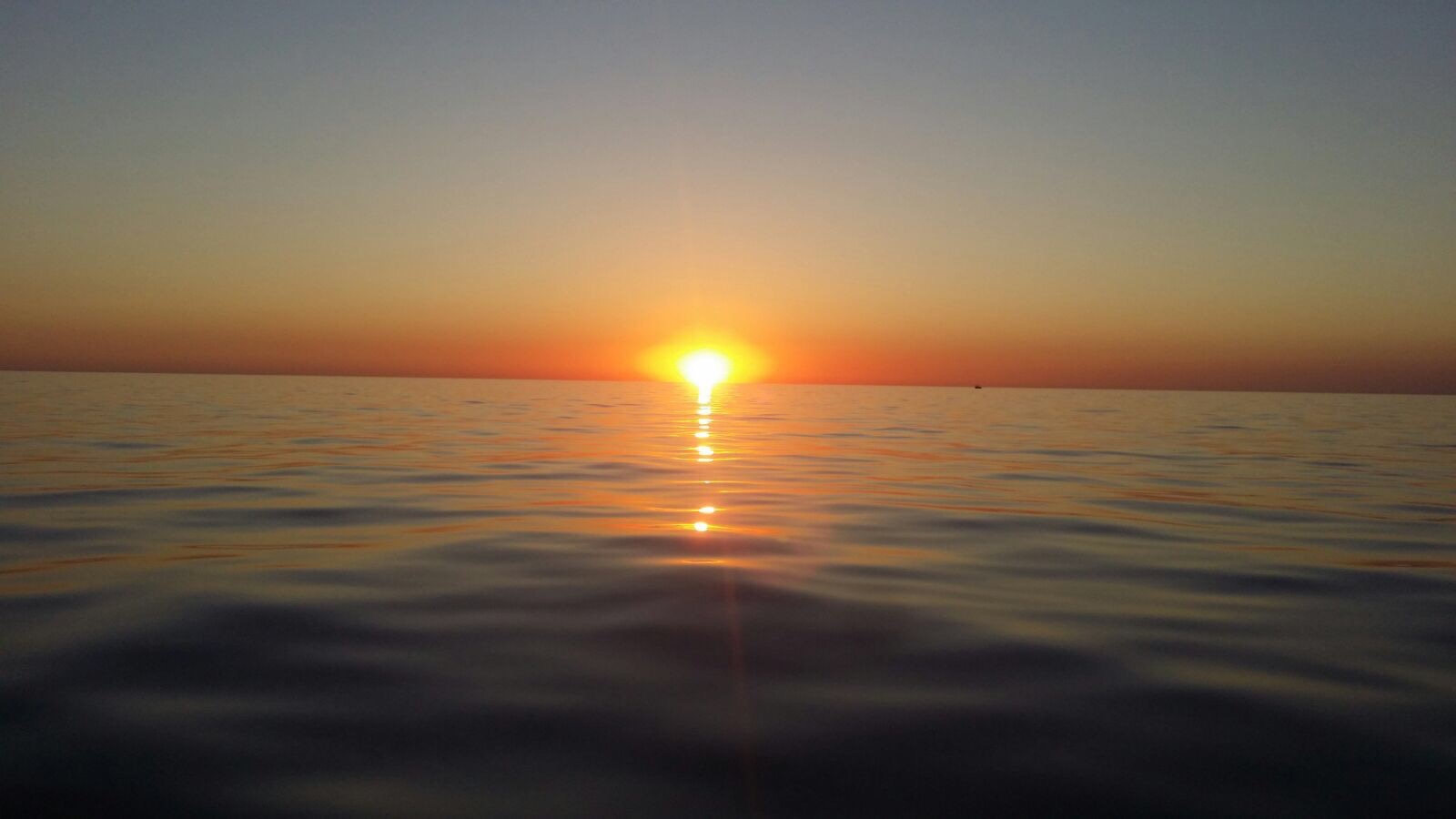 The sun rises through the sea
