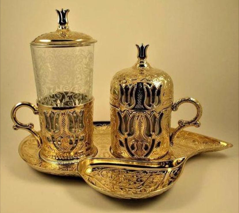 Gold coffee cup and glass on gold tray